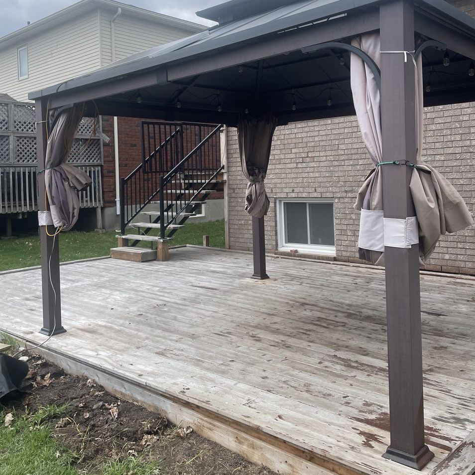 Weathered grey gazebo deck before staining