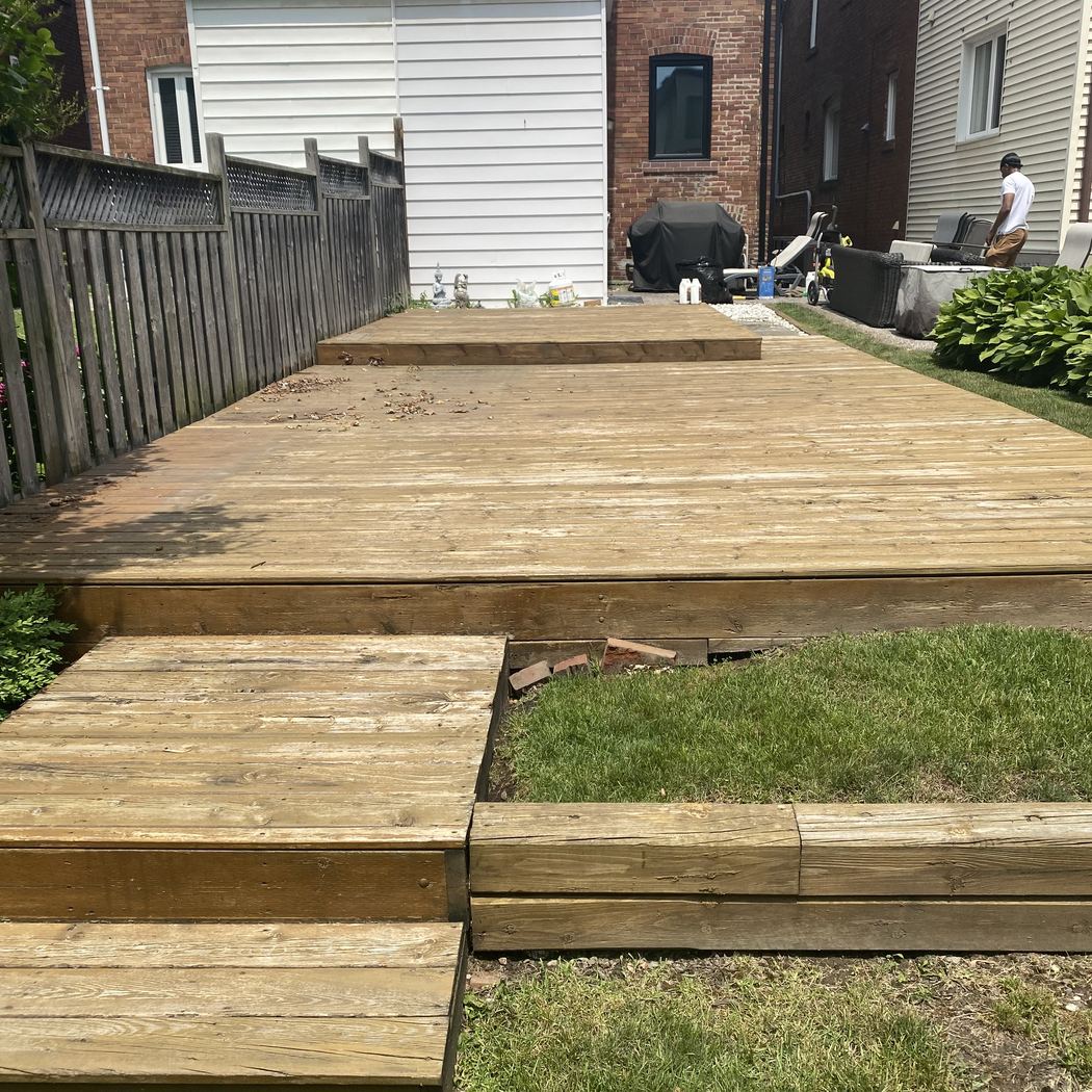 Worn bare-wood backyard deck before refinishing